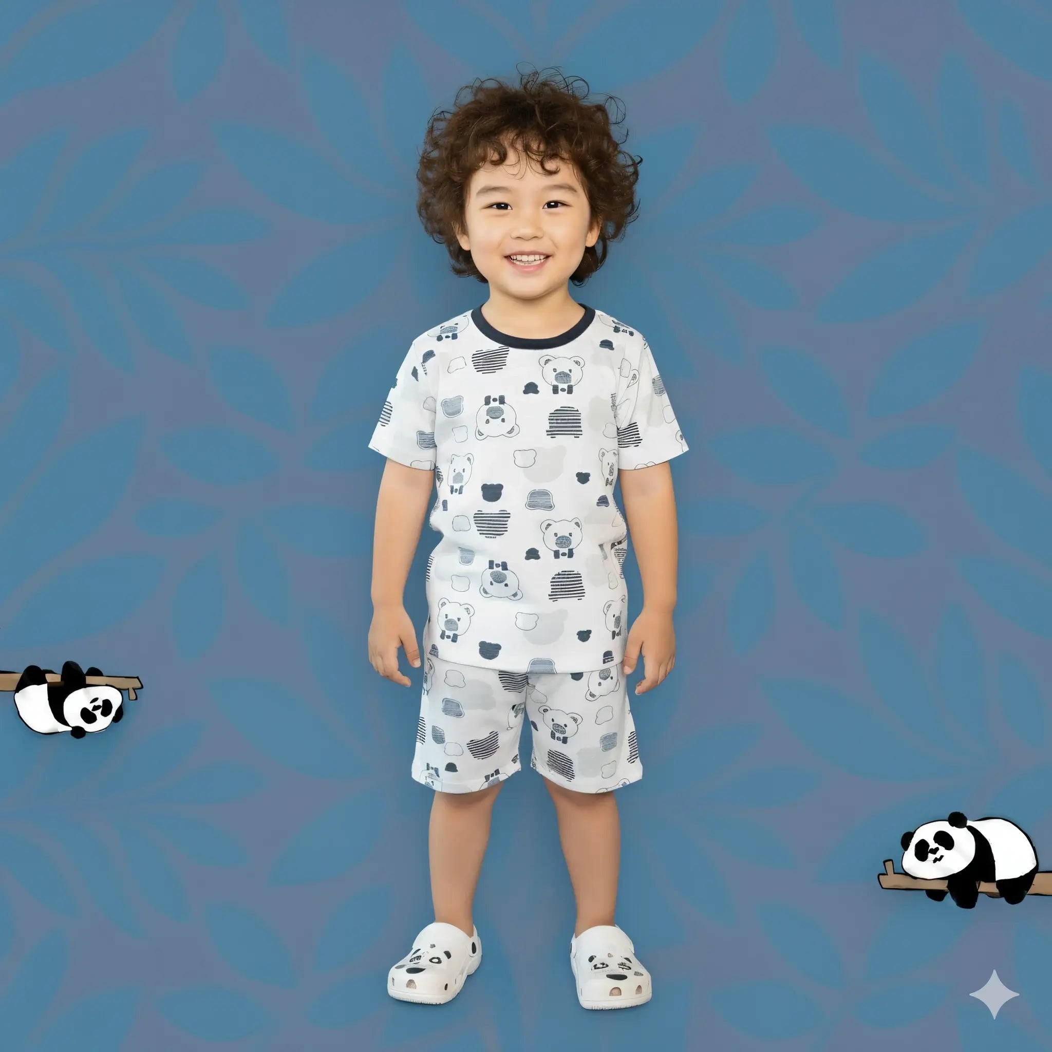 Child wearing a patterned outfit on a blue background with panda illustrations.