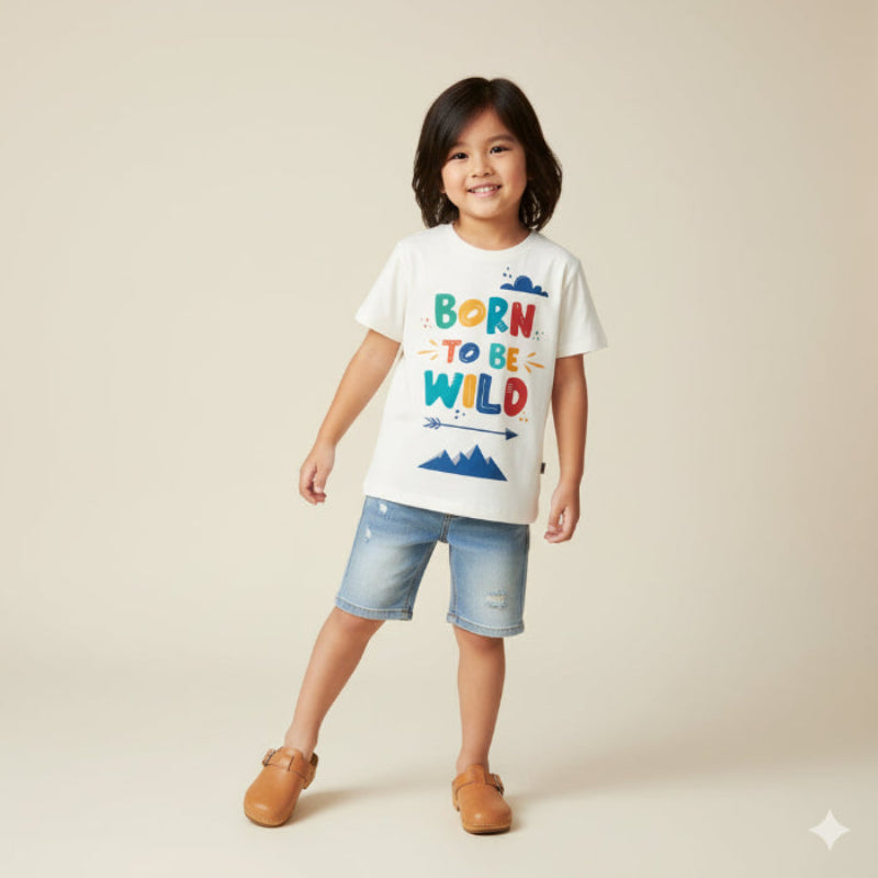 Child wearing a white t-shirt with colorful text and denim shorts on a beige background