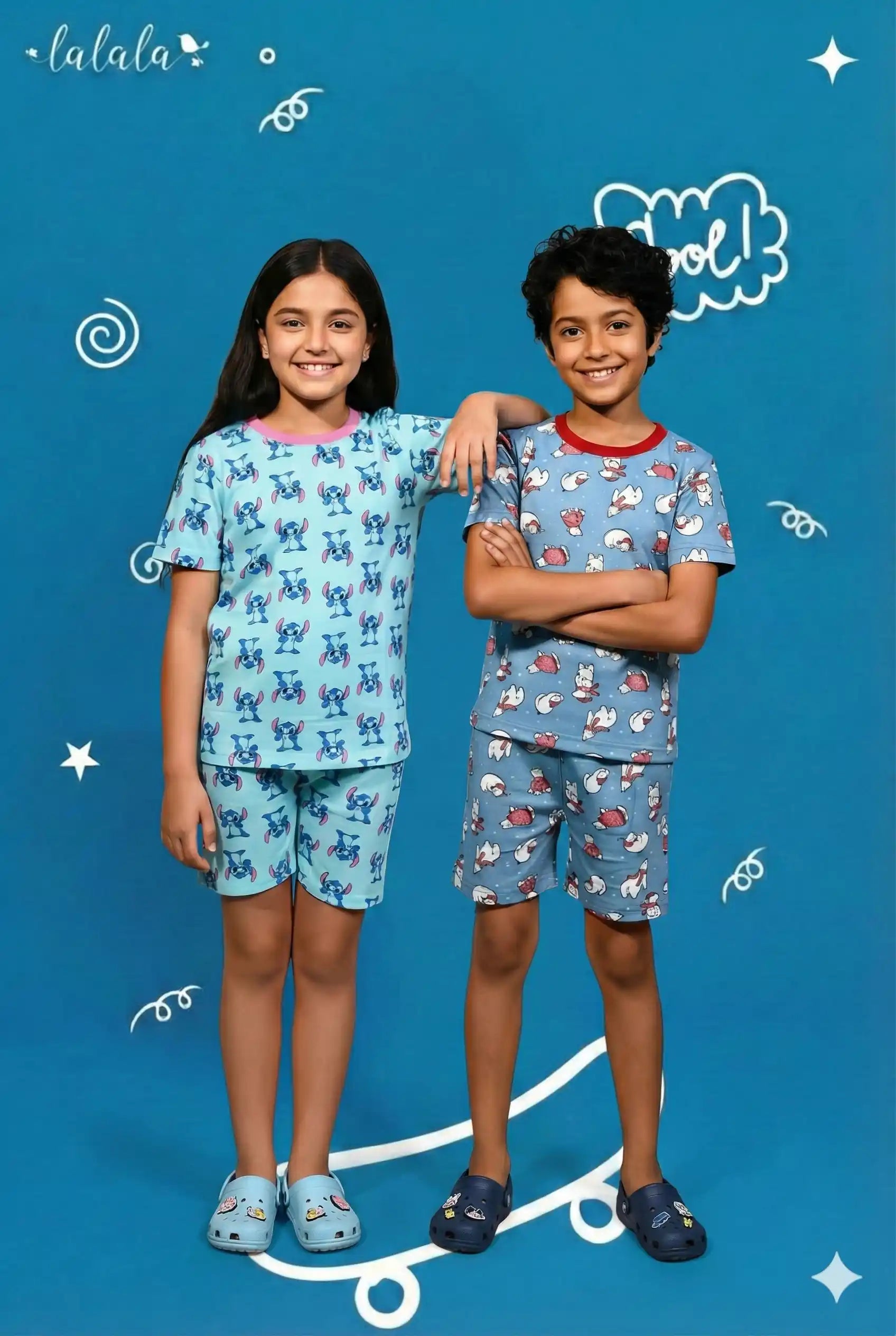 Two children wearing matching pajama sets on a blue background with 'lalala' branding.
