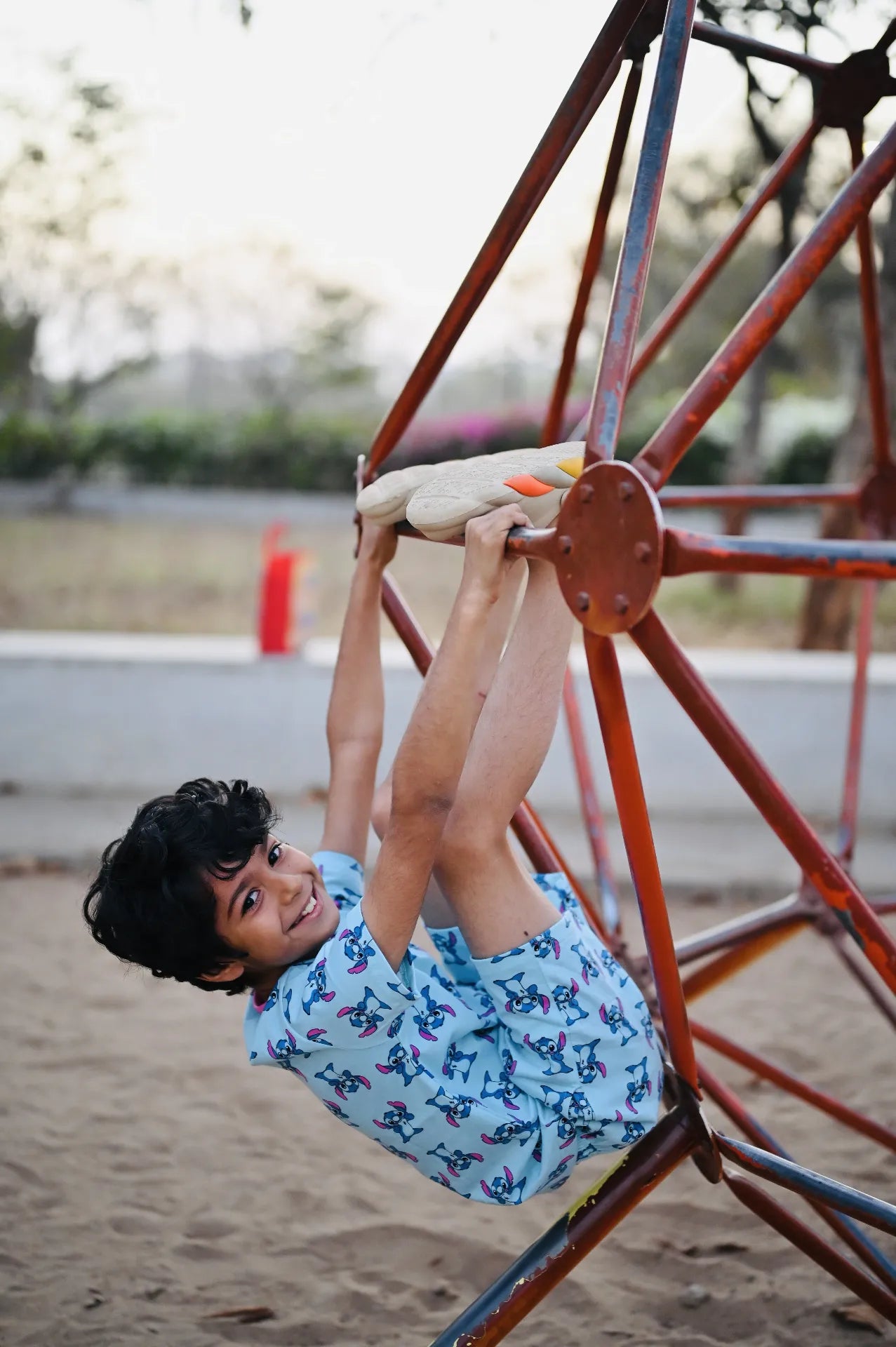 Child playing on a playground swing set with a blurred background