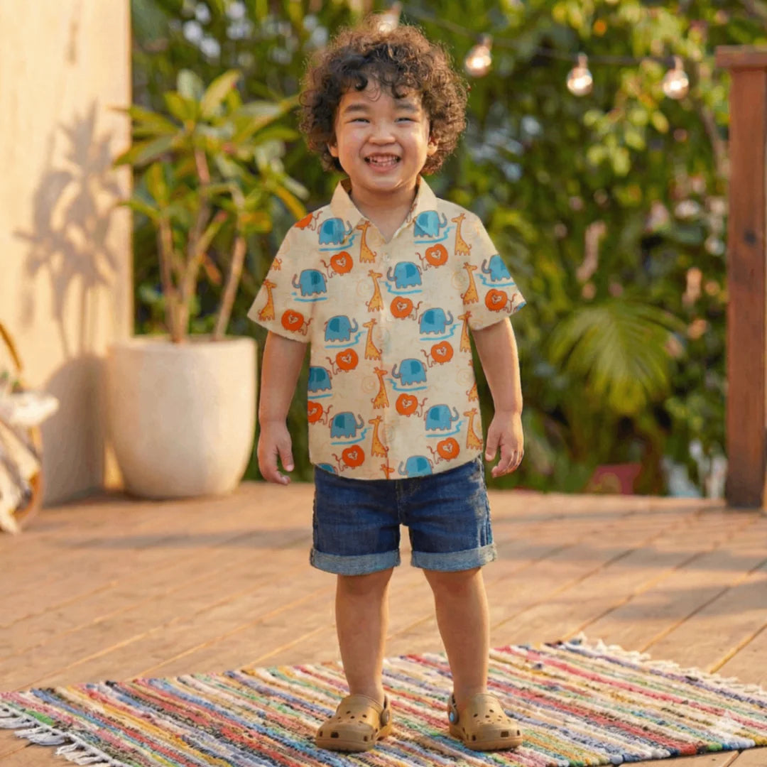 Child wearing a colorful shirt with animal patterns outdoors on a sunny day.
