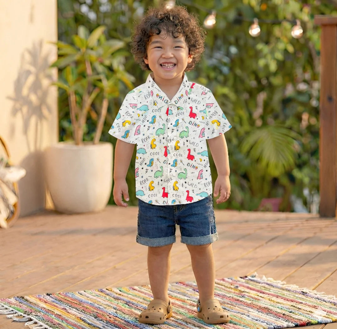 Child wearing a patterned shirt and shorts standing on a colorful rug outdoors.