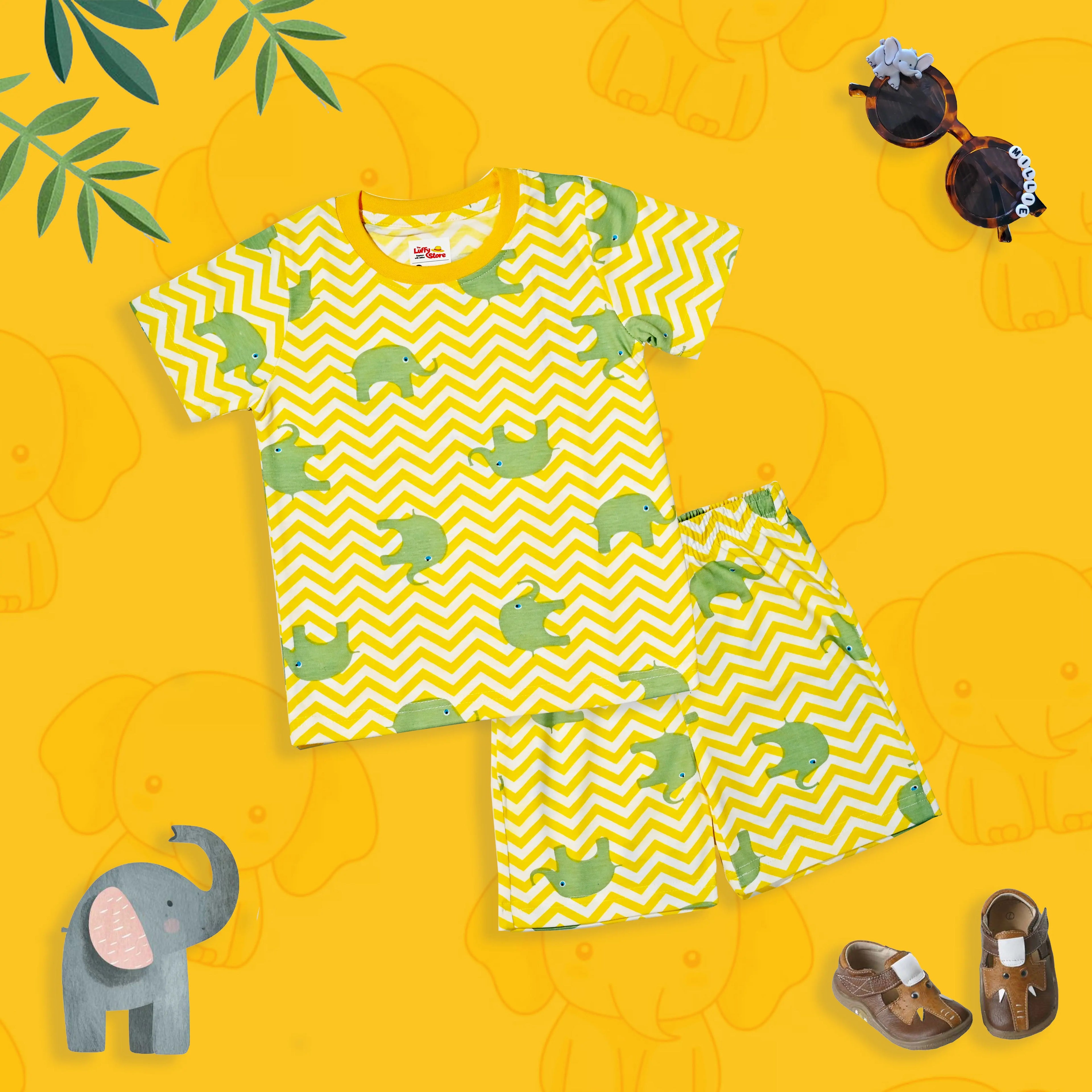 Children's outfit with green turtle pattern on yellow zigzag shirt and shorts on a yellow background with elephant illustrations.