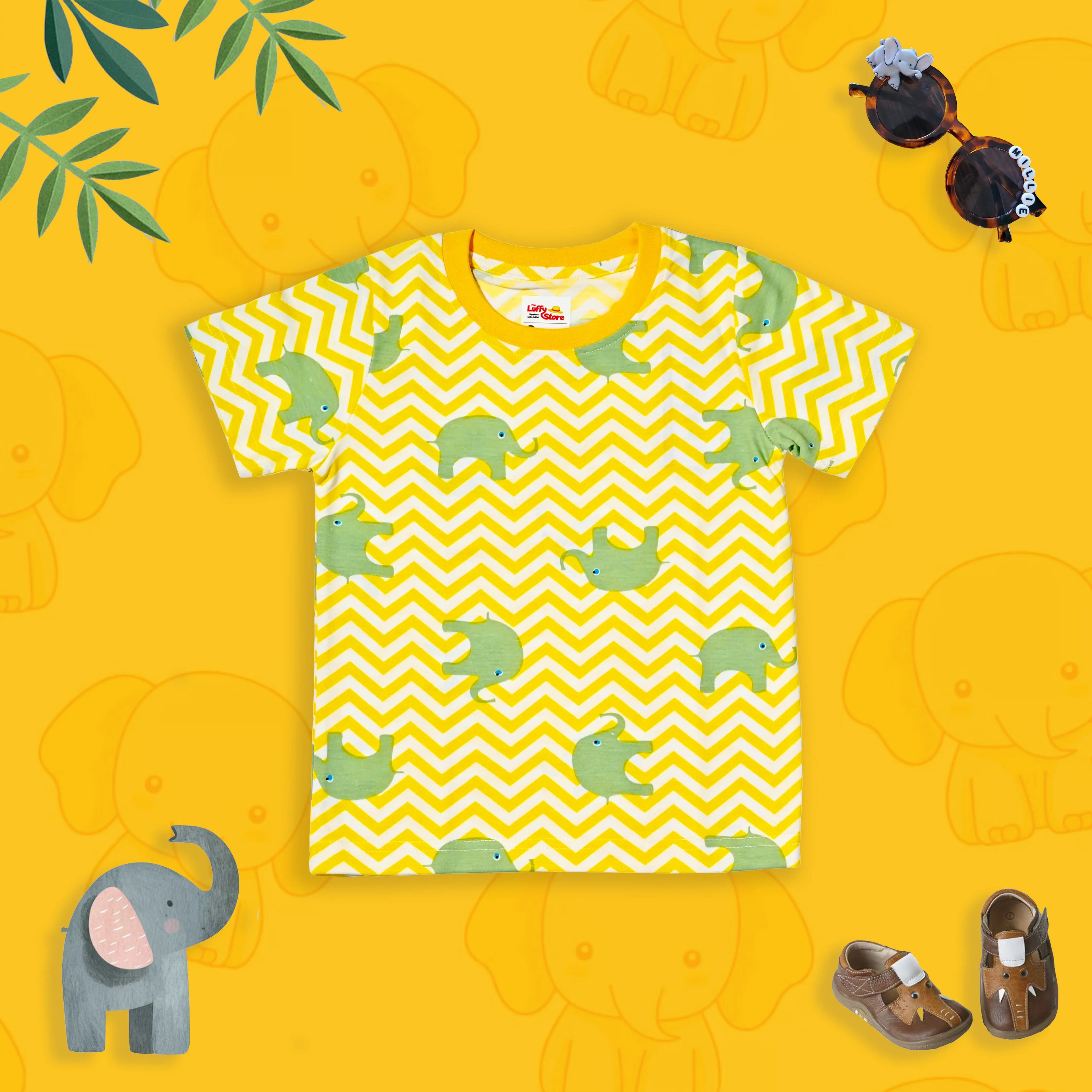 Yellow t-shirt with green turtle pattern on a yellow background with elephant toys.