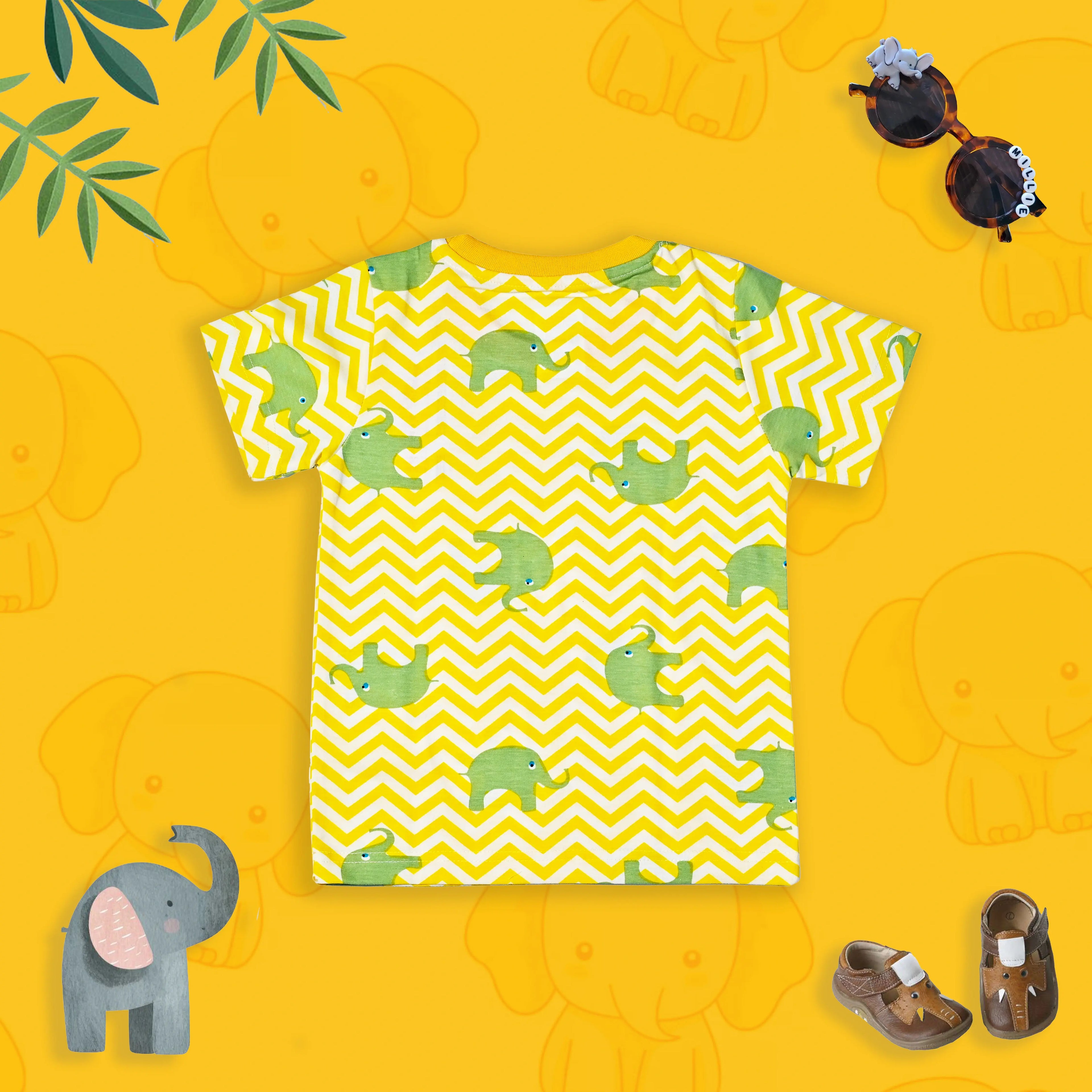 Yellow t-shirt with green elephant pattern on a yellow background with elephant toys.