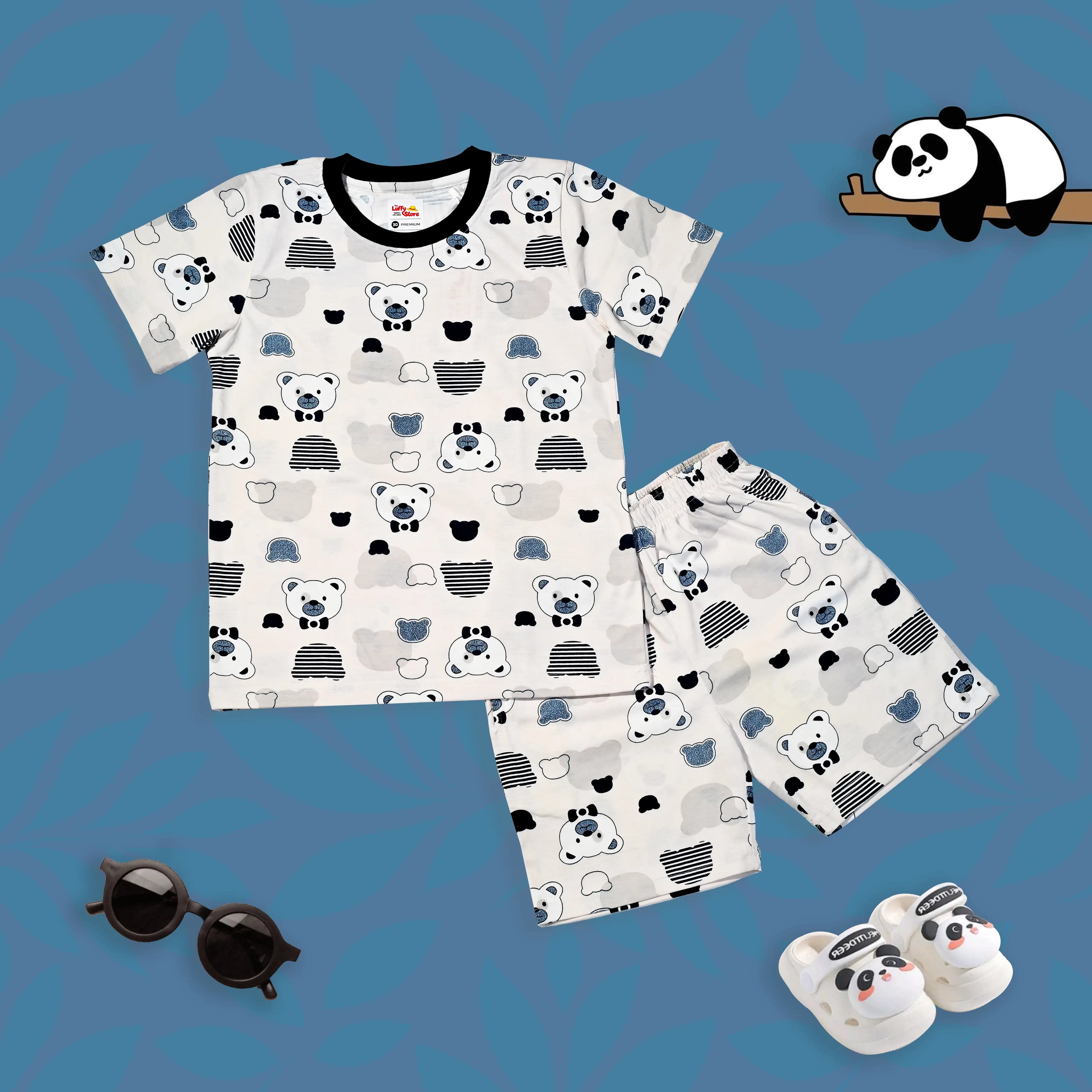 Children's pajama set with panda pattern on a blue background, accompanied by panda-themed slippers and sunglasses.